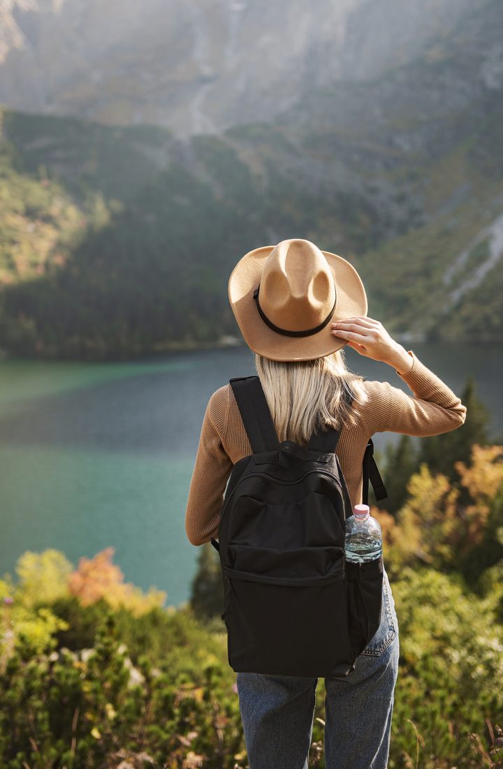 A traveler looking out over a mountain lake